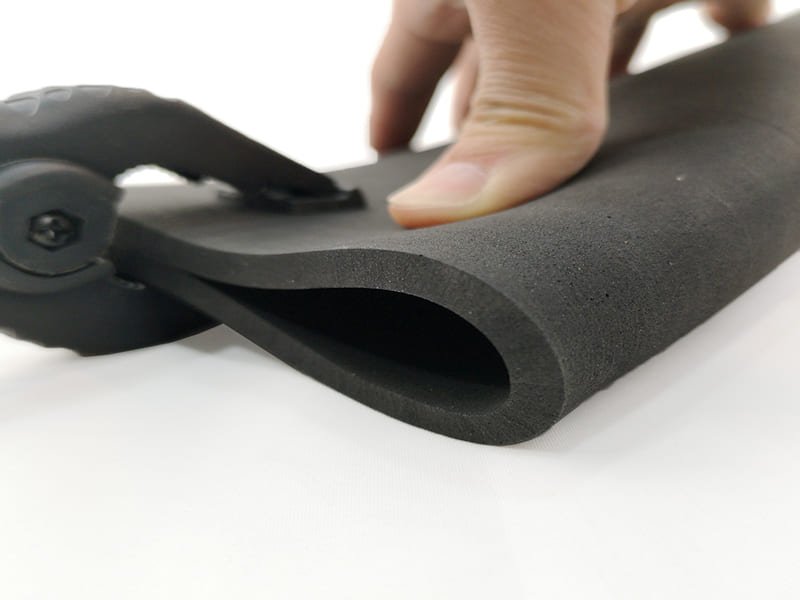 A bottle of pH-neutral floor cleaner next to a damp mop on a clean rubber gym floor.